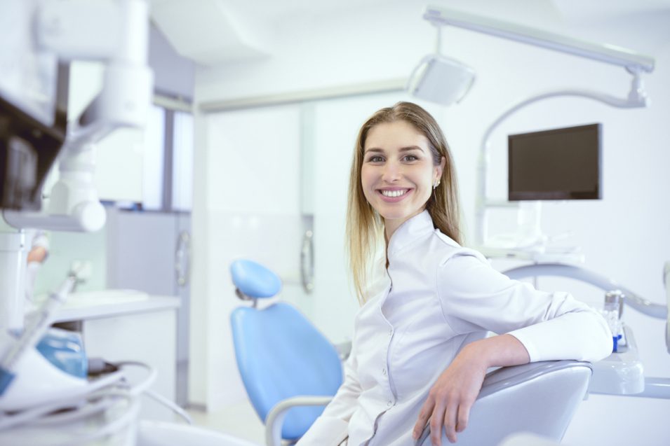 Cute Dentist Technician Smiling While Sitting In Dental Clinic
